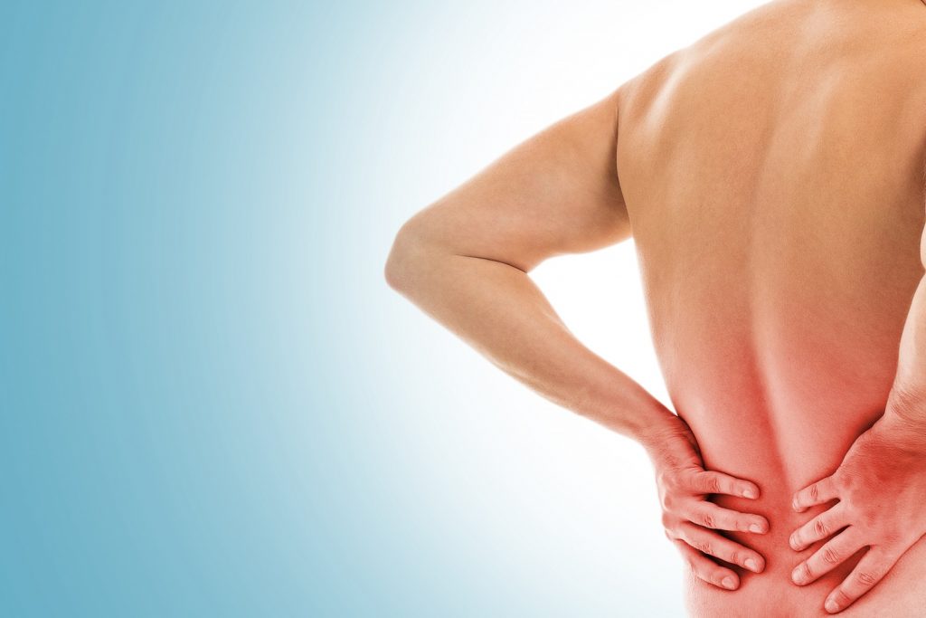 man holds his back due pain