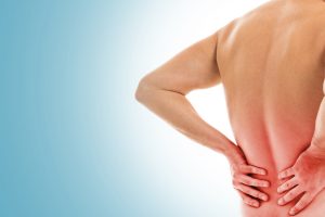 man holds his back due pain